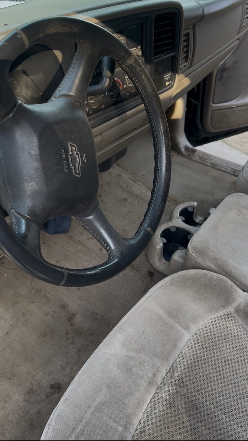 Chevy truck interior before detailing — dusty dash and stained seats